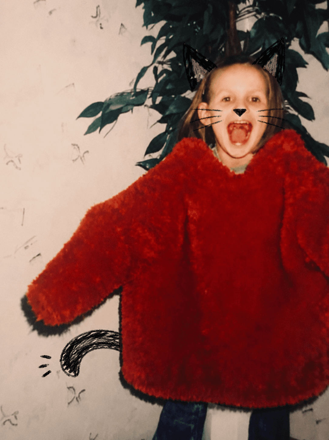 The kitflix mascot — a kid in a black cat costume and a fluffy red sweater, mid-roar.